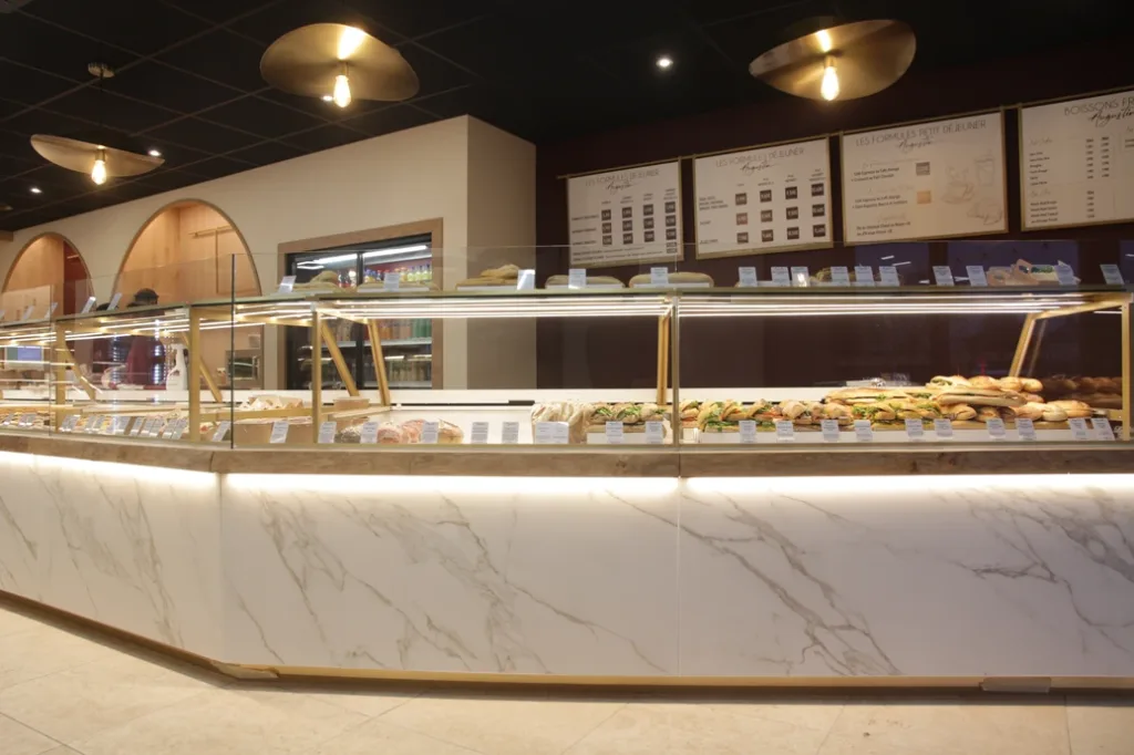 Comptoir en marbre blanc d'Augustin Guingamp avec sandwichs et menus des formules petit-déjeuner et déjeuner