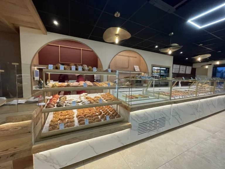 Comptoir de viennoiseries et de pâtisseries du nouvel Augustin Guingamp, sous les arches bordeaux et bois clair